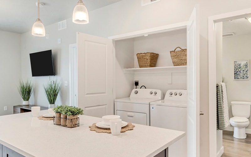 Upscale kitchen island in front of washer and dryer at Millpond pet-friendly apartments in American Fork